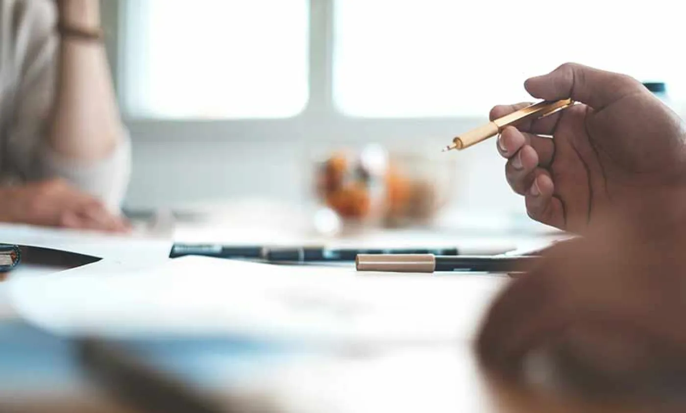 Des mains à une table note quelque chose sur un carnet