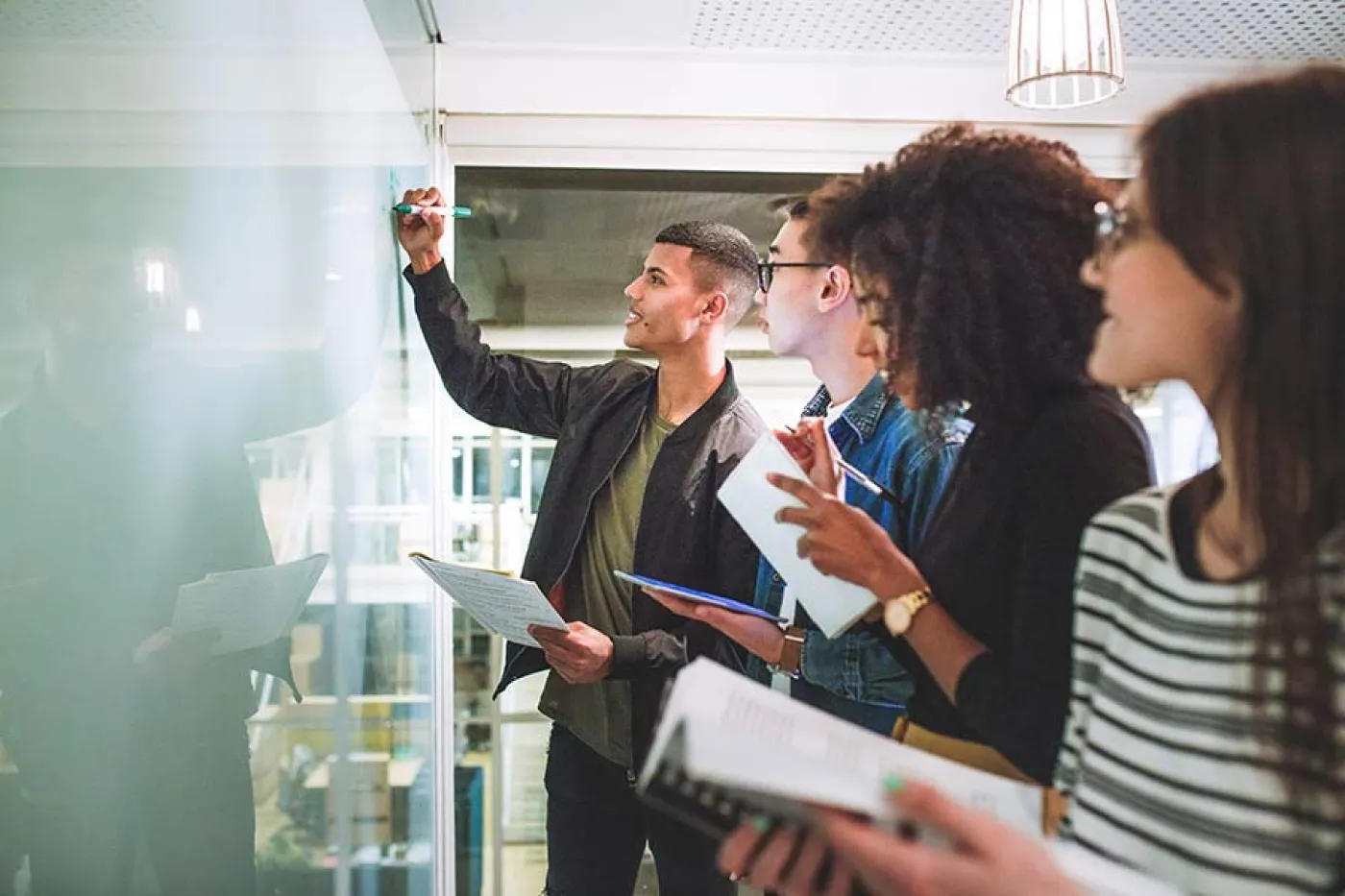 Des étudiants écrivent sur un tableau blanc