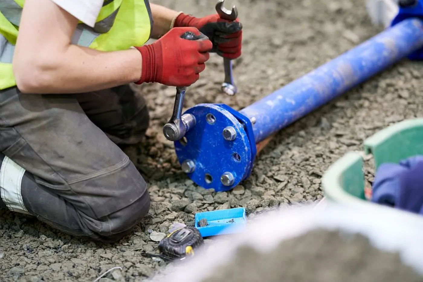 Des mains manipulant un tuyau et des outils