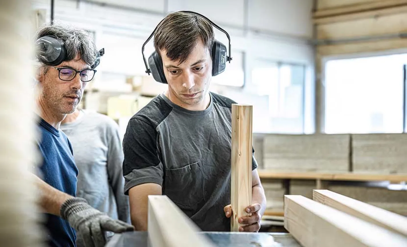 Deux stagiaires usinent un morceau de bois