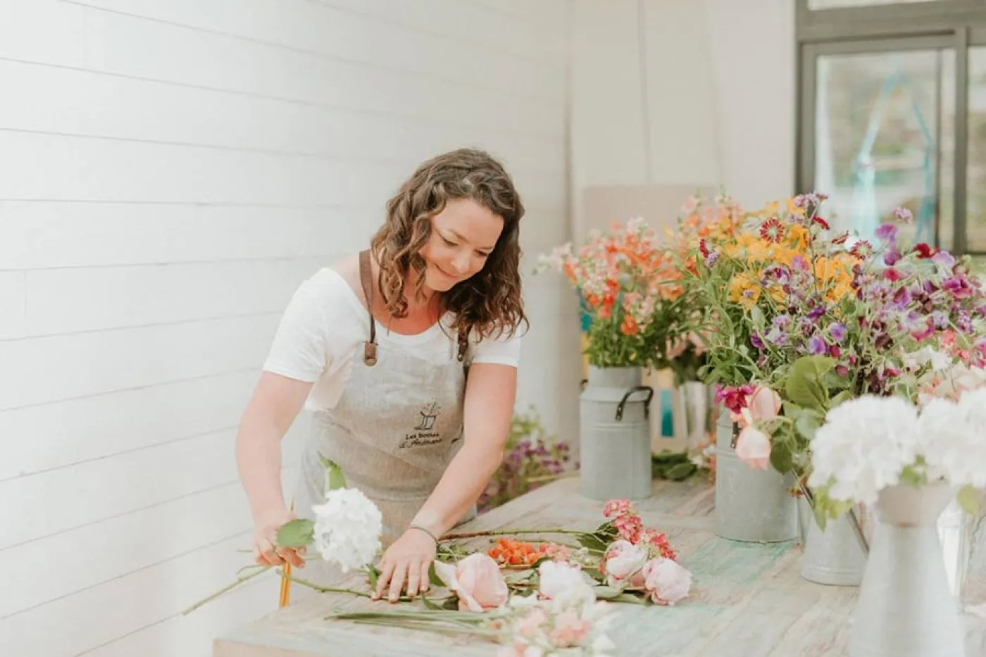 Tiphaine réalise un bouquet de fleurs sur une table
