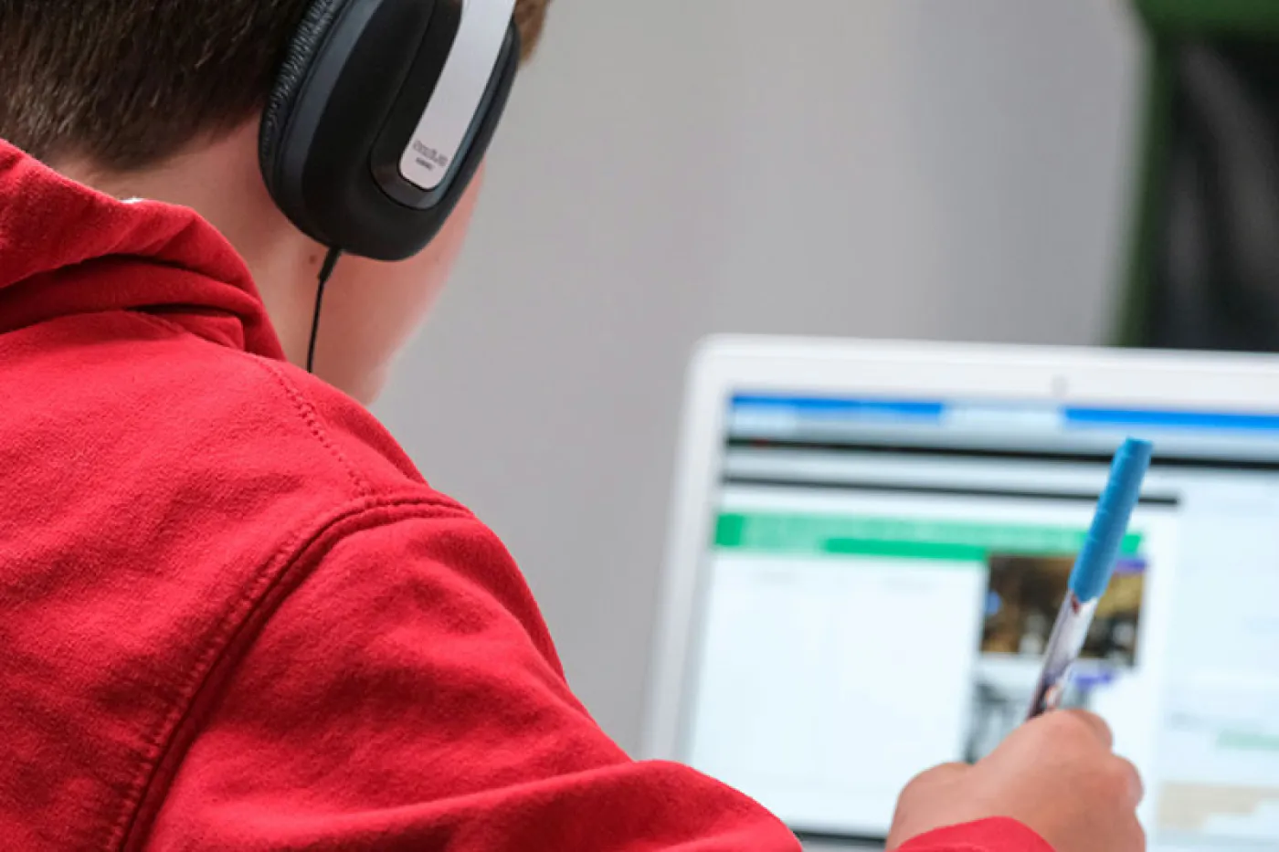 Un collégien de dos devant un ordinateur