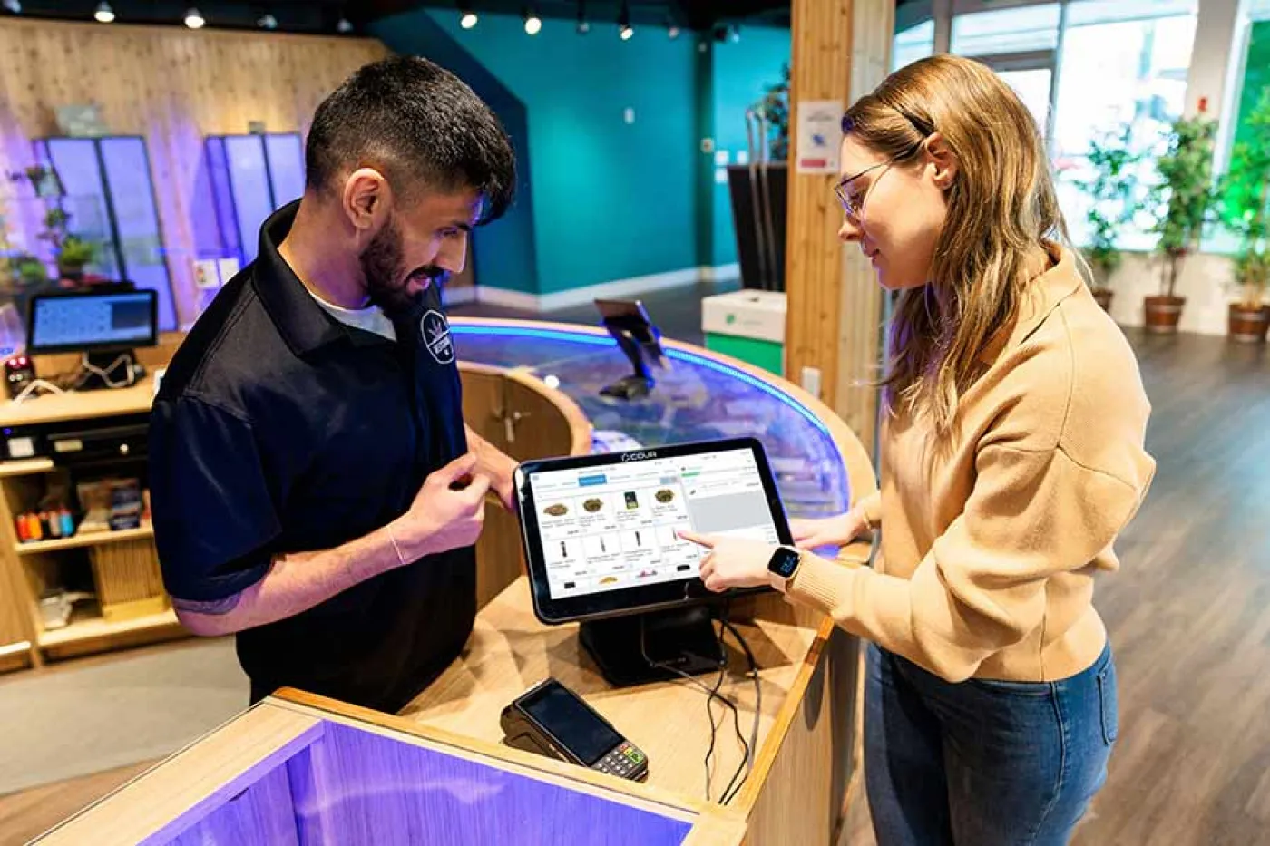 Un serveur montre à une femme comment montre la tablette du restaurant