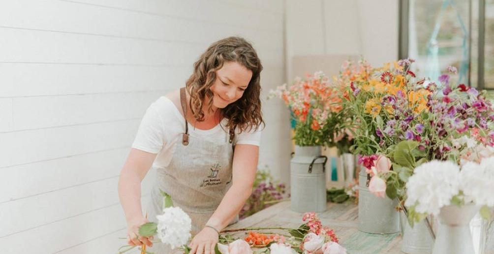 Tiphaine réalise un bouquet de fleurs sur une table