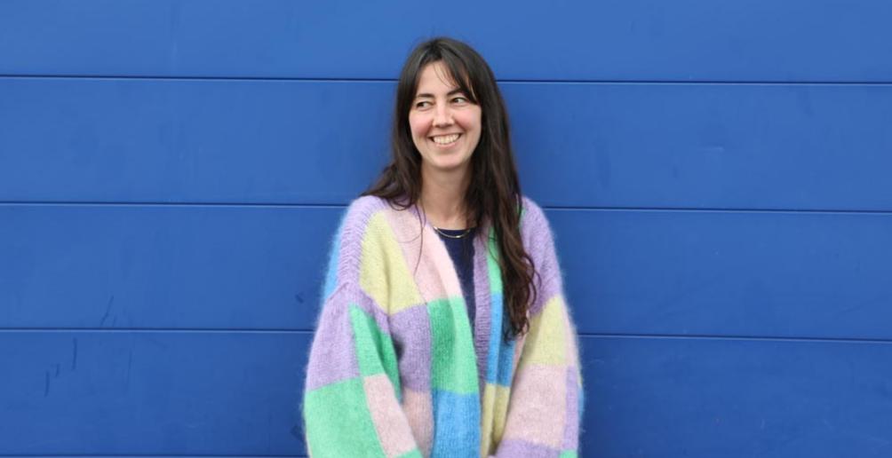 Portrait de Bertille Hinge devant un mur bleu