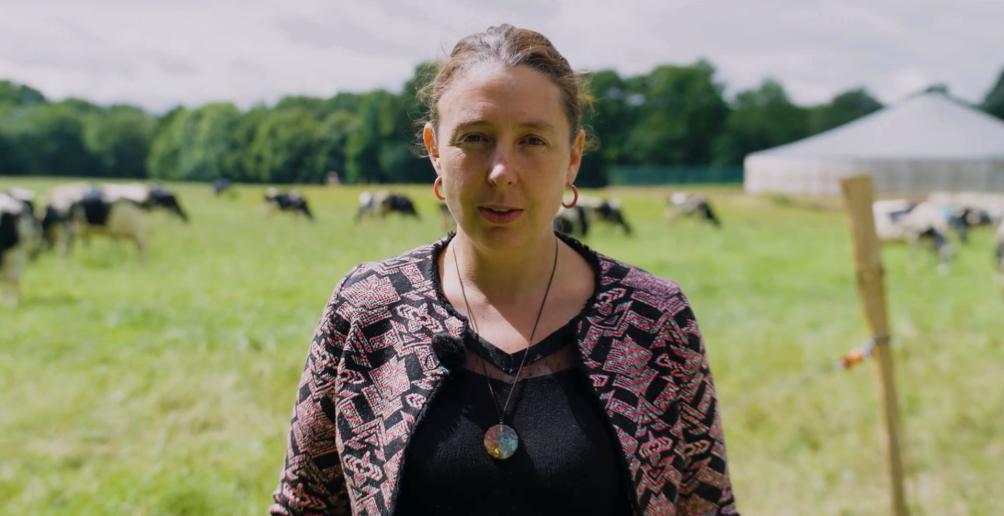 Portrait d'Aurore dans un champ avec des vaches en arrière plan