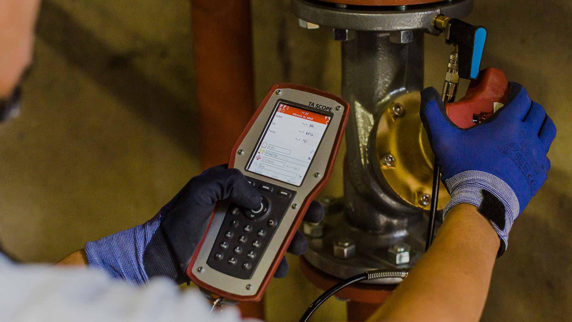Un professionnel contrôle un équipement à l'aide d'un outil de diagnostic hydraulique