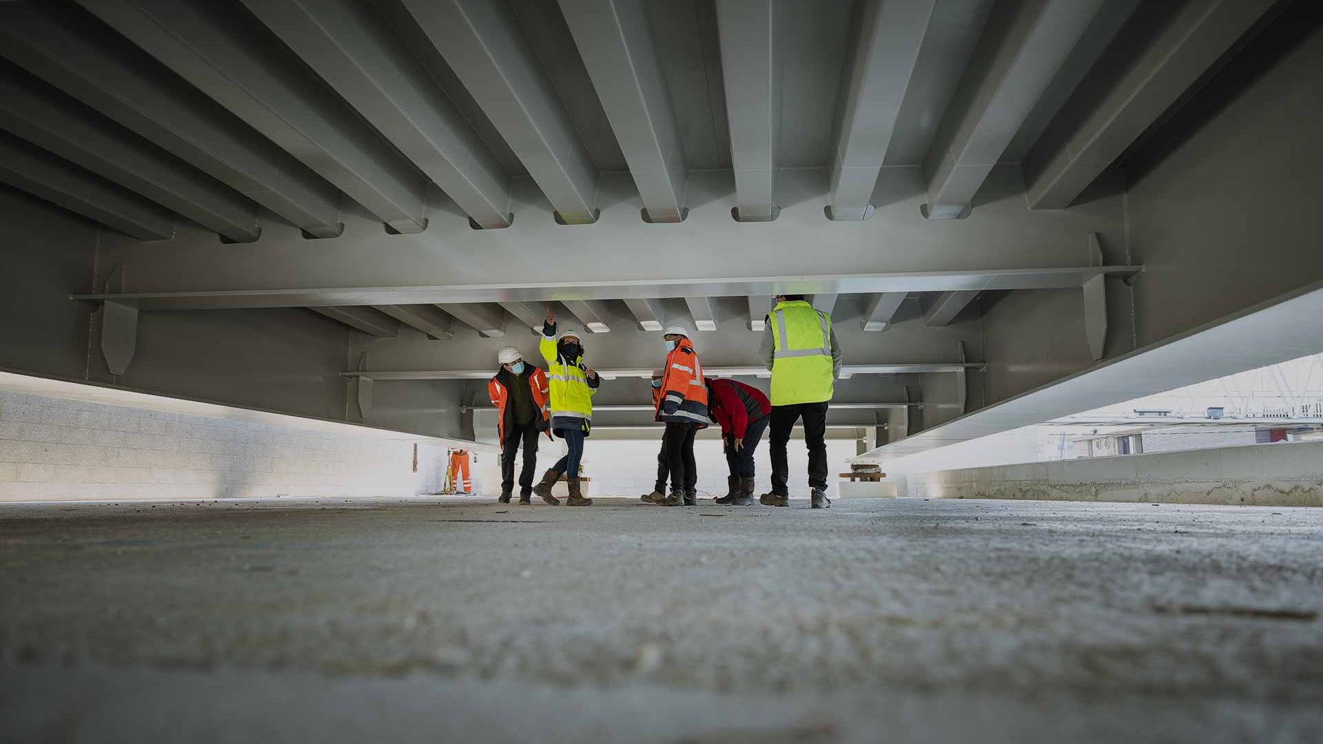 Des professionnels en vêtement de sécurité inspectent le tablier d'un pont