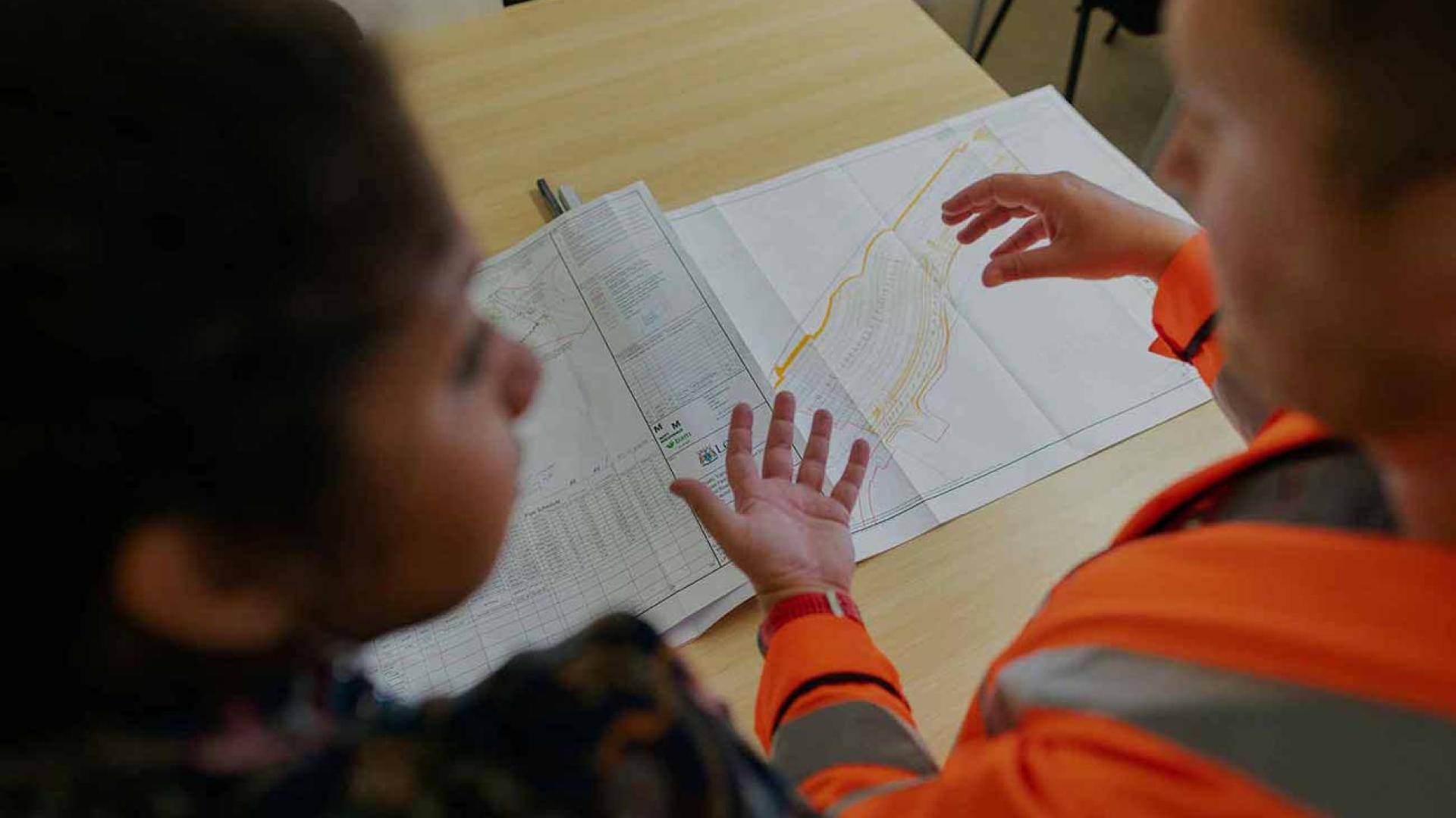 Un homme et une femme discutent à une table devant un plan