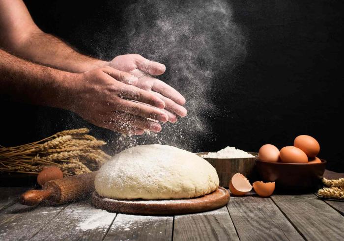 Des mains au-dessus d'une pâte à main