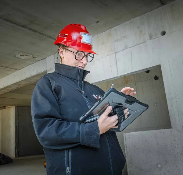 Une conductrice de travaux regarde sa tablette sur le chantier