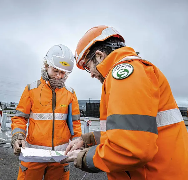 Une cheffe de chantier discute avec un conducteur de travaux sur un chantier