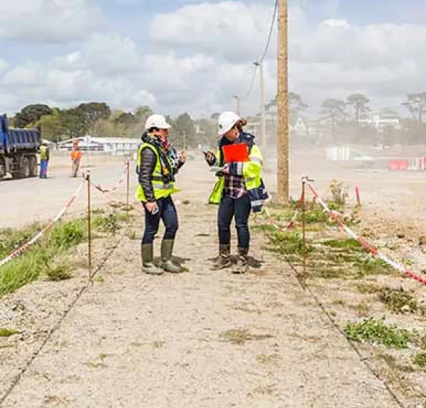 Deux professionnel·les discutent sur un chantier de terrassement