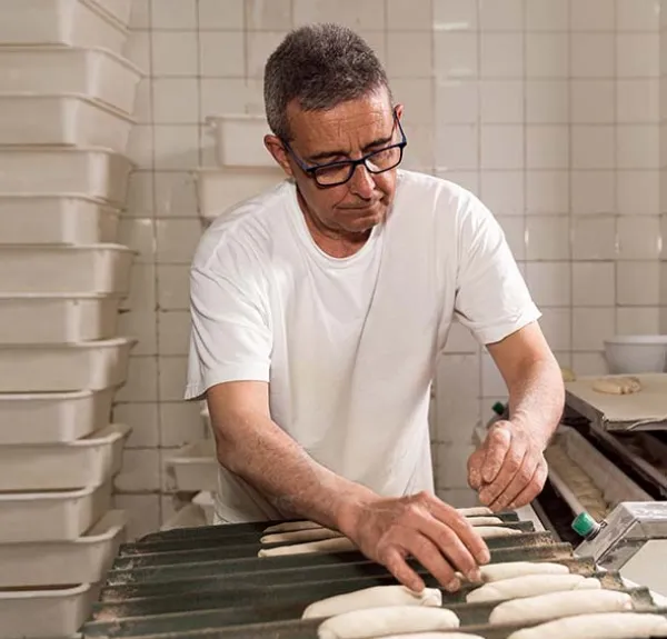 Un boulanger travaille la pâte.