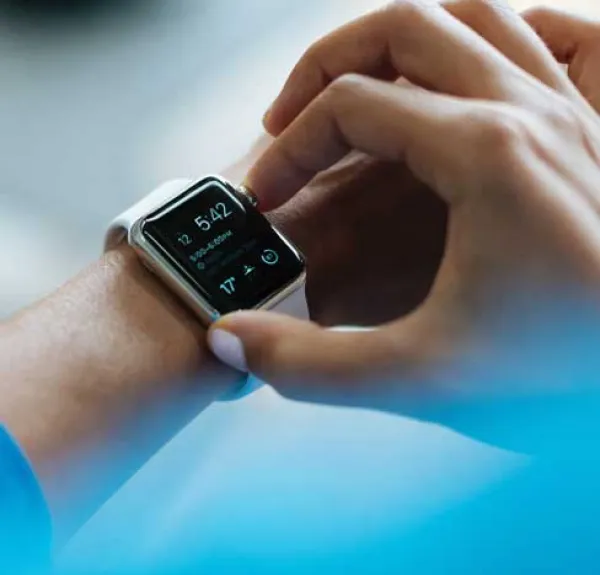 Une main règle une montre connectée sur un poignet