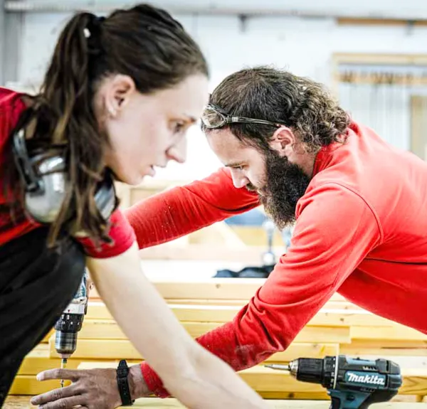 Deux adultes se forment à la construction bois