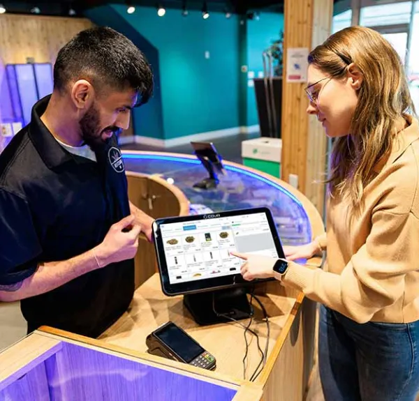 Un serveur montre à une femme comment montre la tablette du restaurant