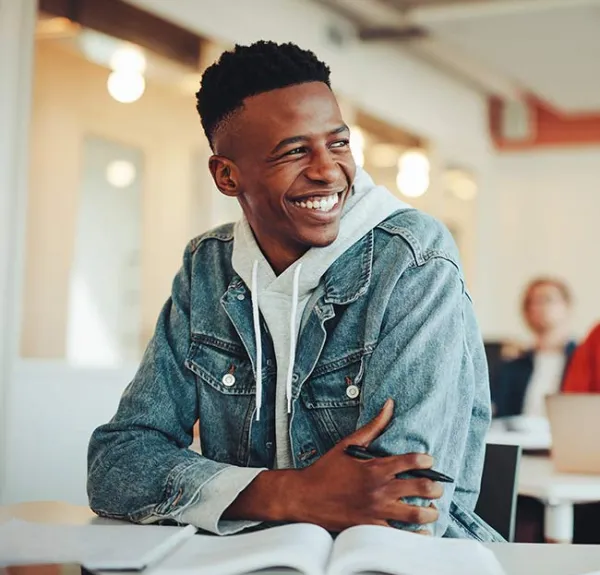 Un étudiant en classe sourit à ses camarades
