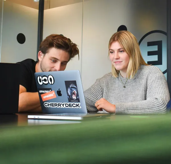 Deux jeunes étudiants regardent un ordinateur portable à une table