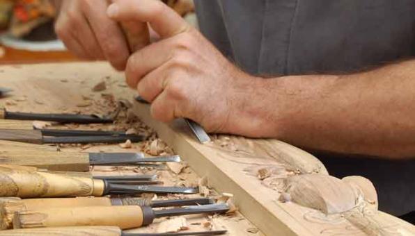 Mains sculptant des fleurs sur du bois