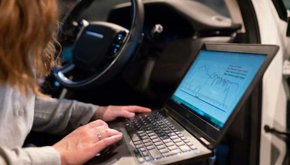 Ingénieure faisant des tests dans une voiture avec son ordinateur portable