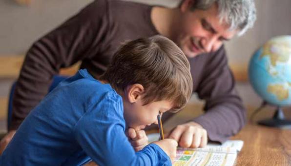 Un Technicien de l'intervention sociale et familiale aidant un enfant à faire ses devoirs