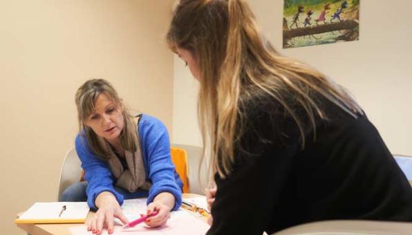 Une assistante de service social conseille une femme bénéficiaire d'aides
