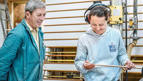 Une stagiaire en formation bois rit avec son formateur