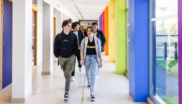 Des lycéens et lycéennes marchent dans un couloir d'établissement