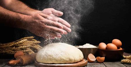 Des mains au-dessus d'une pâte à main
