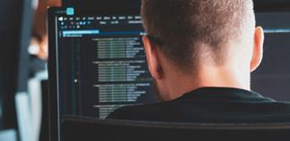 Un homme de dos face à son PC