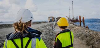 Deux professionnelles sur un chantier regardent des engins