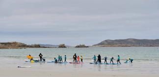Cours de surf pour enfants sur une plage en Bretagne