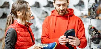Une vendeuse conseille un client sur des chaussures de course