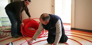 Hommes posant une boucle de chauffage pour plancher chauffant