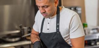 Un pâtissier découpe un gâteau.