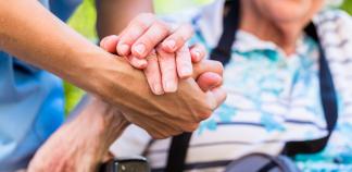 Une main soutient une main de personne âgée