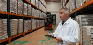 Un responsable logistique prend des notes dans un atelier.