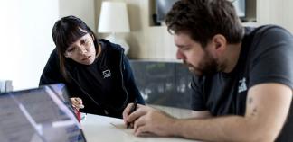 Un professionnel donne des explications à une jeune à un bureau